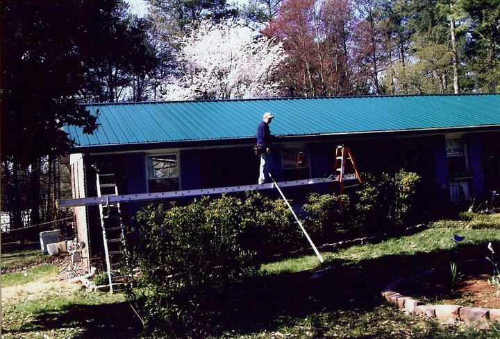 A man installing gutters on a shed