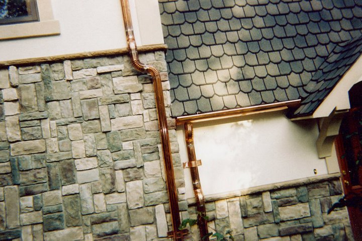 Shiny copper gutters on a stone house