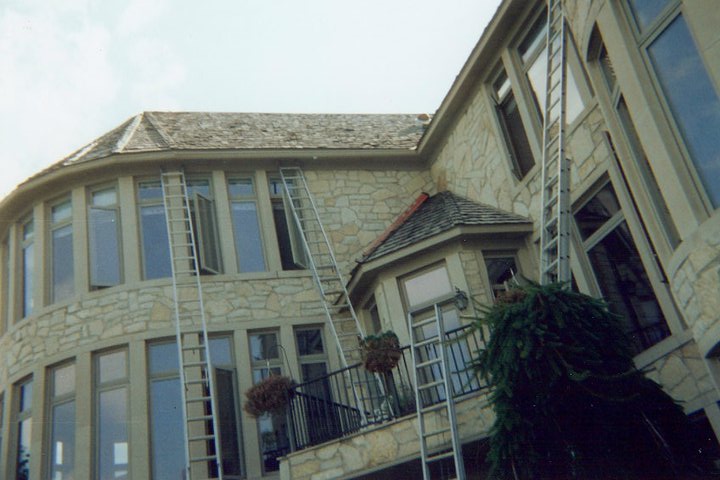 In-progress gutter installation on a large home