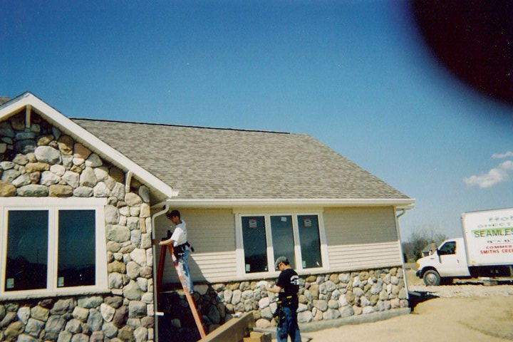 Men installing gutters on a new home
