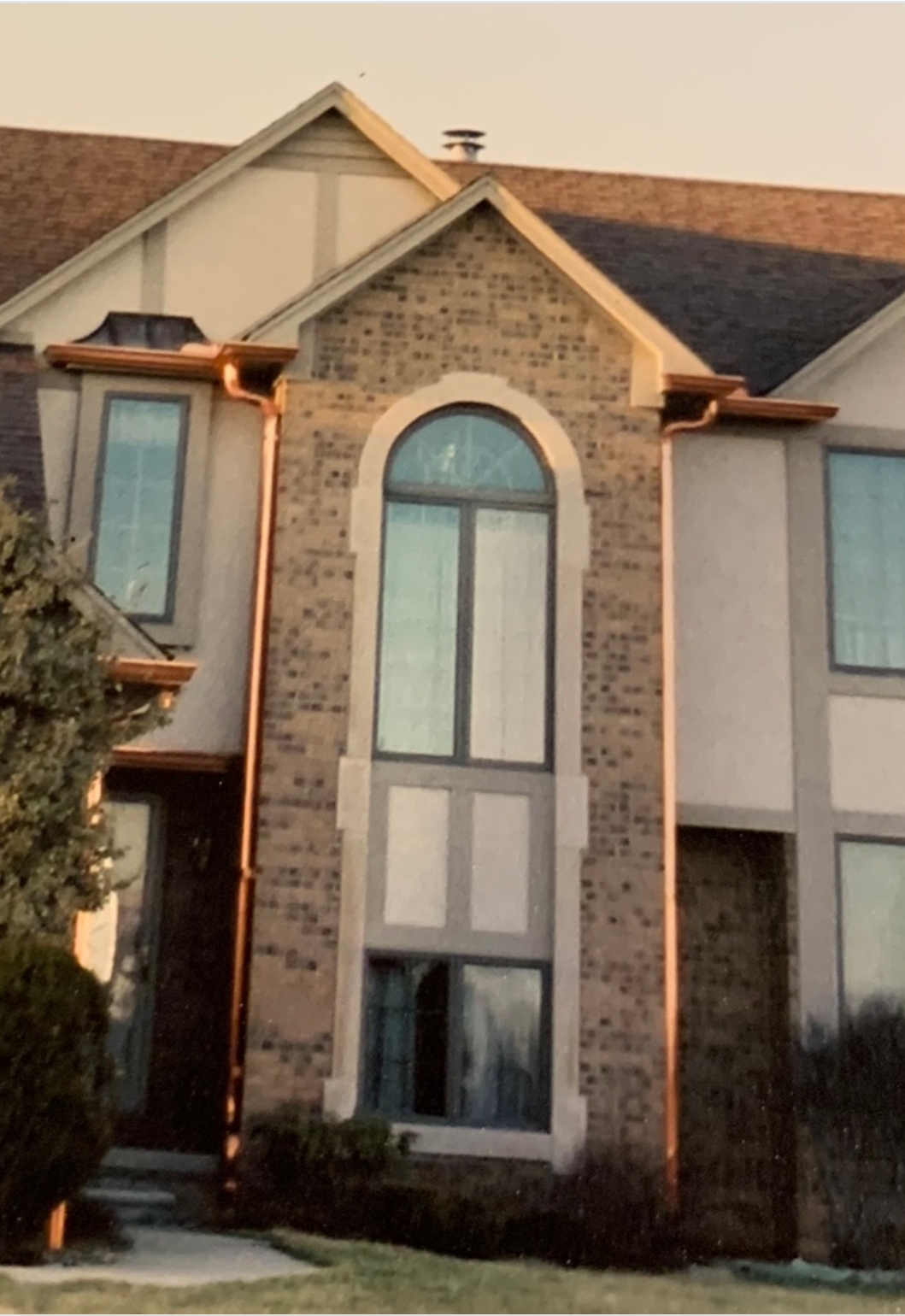 A tall, two-story house with newly installed gutters