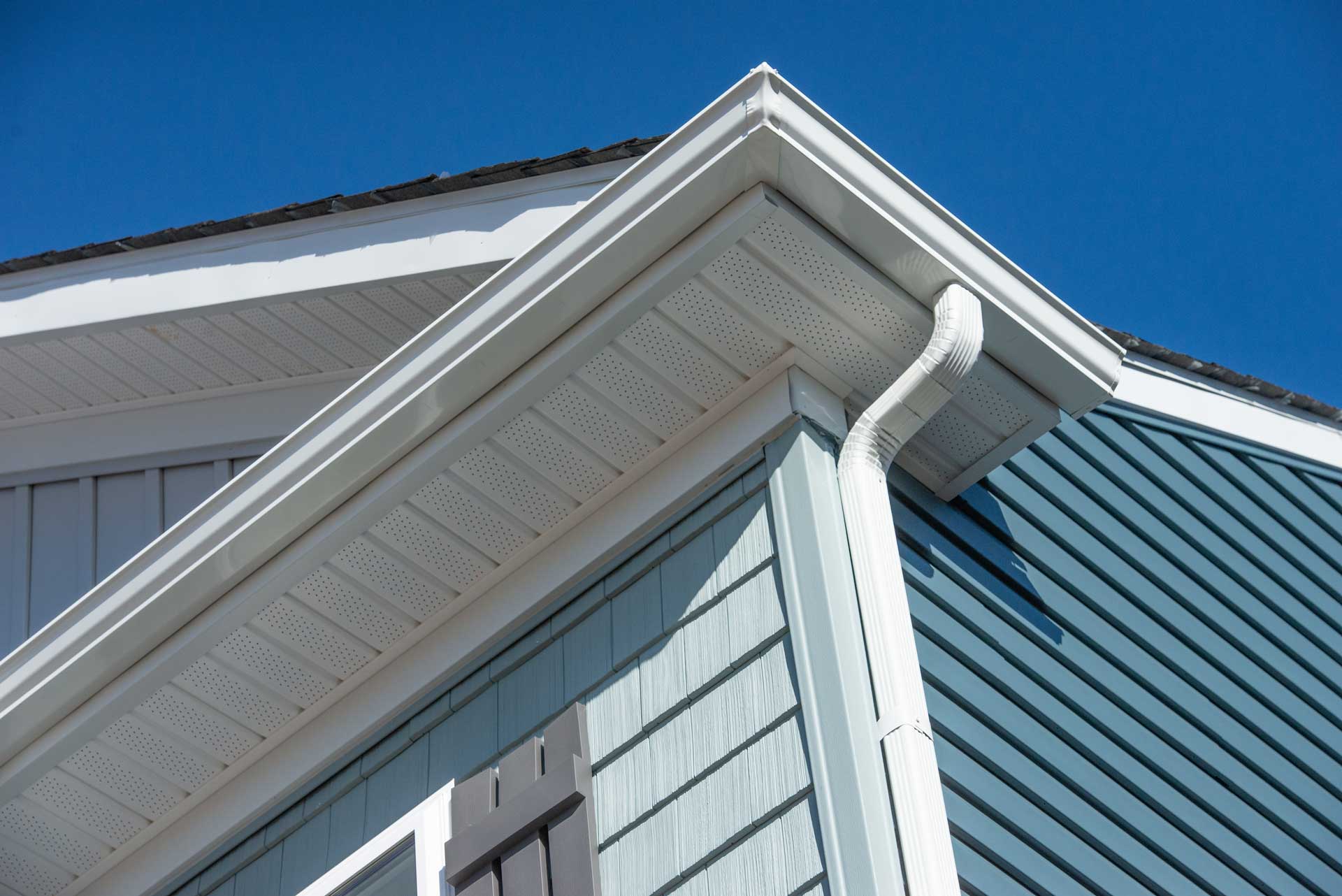 Low-angle shot of blue house with white gutters